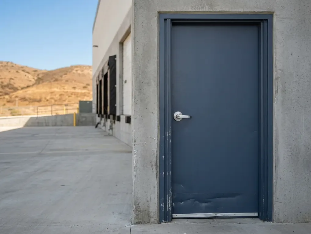 Hollow metal man door with rim exit device on a concrete tilt-up warehouse in Otay Mesa, San Diego